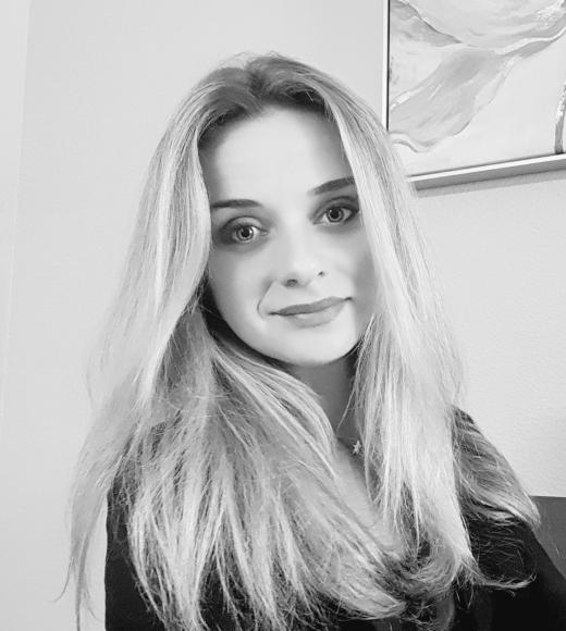 Black and white photo of Jekaterina smiling at the camera.