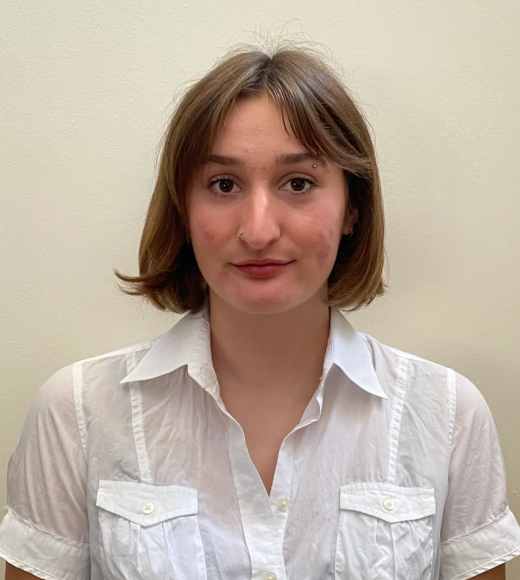 Portrait of young person with short brown hair wearing white button-down shirt